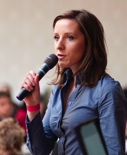Young woman with microphone giving a public talk